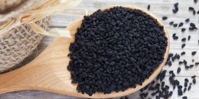 Black cumin seeds in a wooden spoon